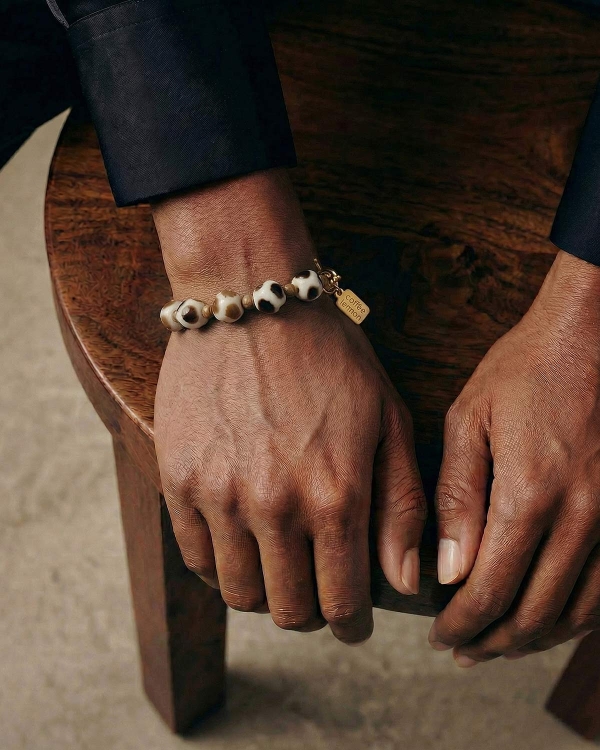 браслет с бусинами жирафа крупным планом на руке